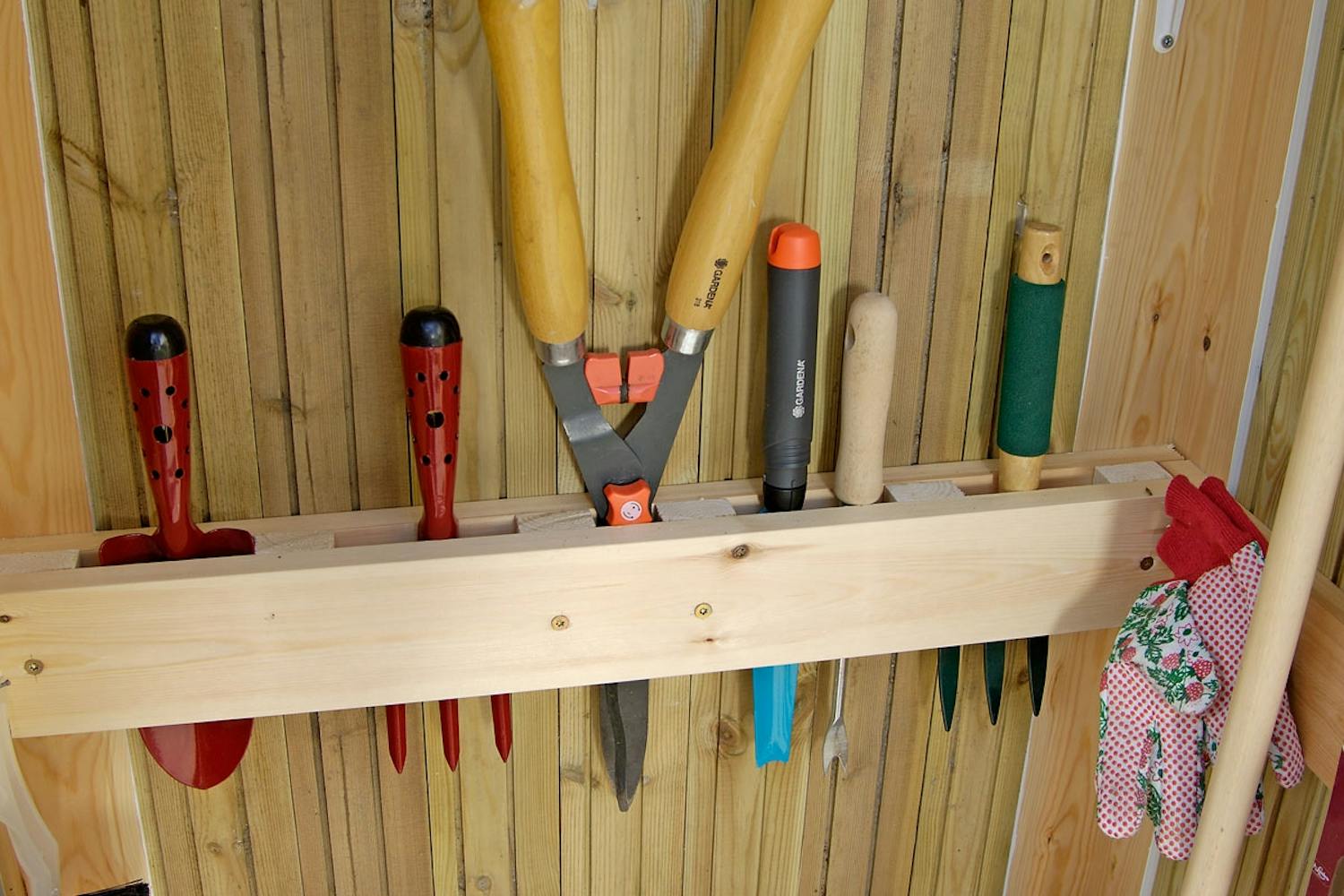 Kahdesta laudasta ja muutamasta välikappaleesta syntyy teline pienille puutarhatyökaluille. Kahdesta laudasta ja muutamasta välikappaleesta syntyy teline pienille puutarhatyökaluille.